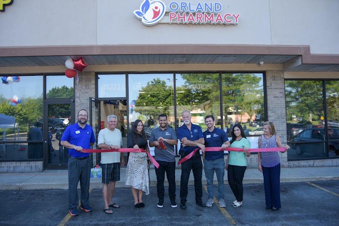 Ribbon cutting in front of the Orland Pharmacy storefront in August 2022