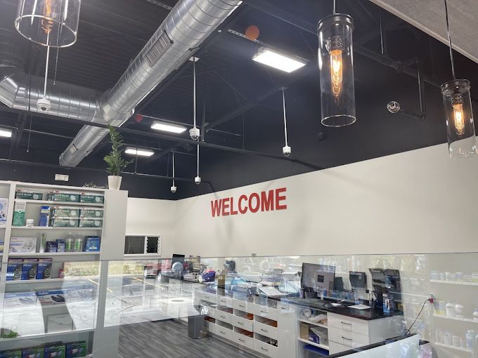 Inside Orland Pharmacy in Homer Glen: the red WELCOME wall above the pharmacy counter